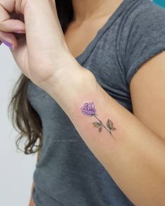 a woman with a purple rose tattoo on her arm