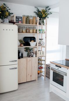 a white refrigerator freezer sitting inside of a kitchen next to a stove top oven