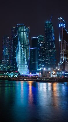 the city is lit up at night with bright lights on it's skyscrapers