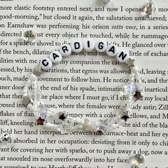 a bracelet made out of beads with words written in them on top of an open book