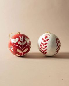 two red and white ornaments sitting next to each other