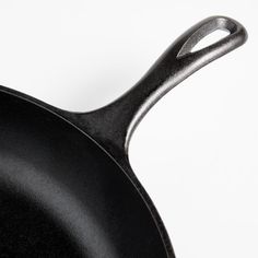 a black frying pan on a white background with the handle extended to the side