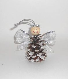 a pine cone angel ornament on a white background