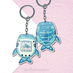 two blue and white keychains with cartoon animals on them