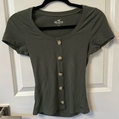 Dark Green / Olive Green Short Sleeve Top With Decorative Buttons Down New Without Tags - No Flaws! Coming From A Clean, Smoke And Pet Free Environment! Question? Leave Me A Comment Below! Fast Shipping On All Orders! No Returns Serious Inquires Only! I Take Pictures And Video Of Sold Item/S During Packaging For Security! Make Sure To Accept Your Order Once Received Or I Will Not Sell To You Again :) Rack #4 Green Shirts, Lace Front Top, College Wear, Olive Green Shorts, Earthy Outfits, Ribbed Shorts, Hollister Shorts, Green Olive, Scoop Neck Tee