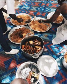 several people sitting at a table with plates of food on it and bowls of food in front of them