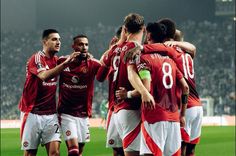 a group of men standing on top of a soccer field next to eachother