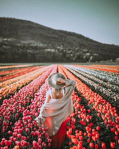 a woman standing in a field of flowers with a hat on her head and the caption instagram