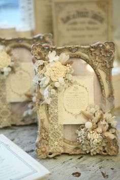 two ornate frames with flowers on them are sitting on a table next to some papers