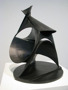 a black sculpture sitting on top of a white pedestal