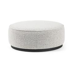 a white round ottoman with black trim on the top and bottom, against a white background