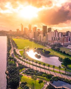 an aerial view of a city and the river in front of it at sunset or sunrise