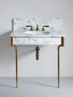 a bathroom sink with two faucets and a marble counter top