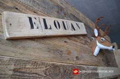 a deer head mounted to the side of a wooden wall with a sign that says ellouann