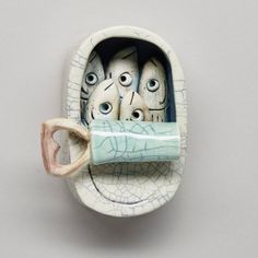 there is a ceramic cup with eyes in the shape of a mouth and two cups inside it