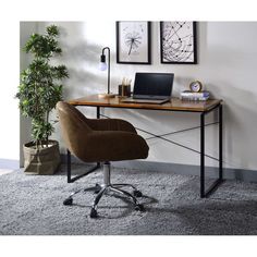 a desk with a laptop on it next to a potted plant