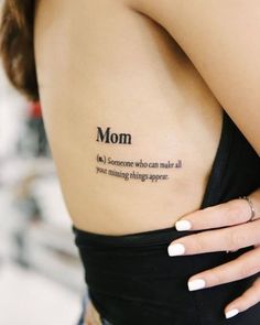 a woman with a tattoo saying mom on her back