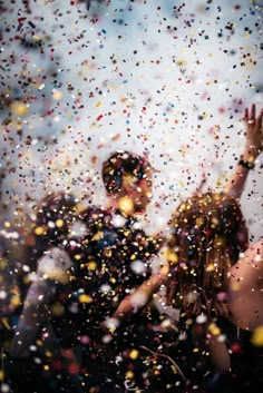 two people standing in front of a window covered in confetti