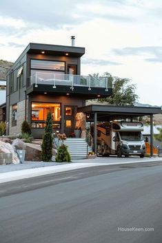 a truck is parked in front of a house with a car attached to the garage