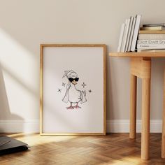 a white framed art print with a cartoon penguin wearing sunglasses and holding a star in its hand