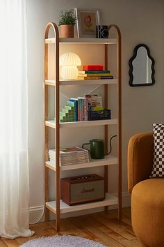 a living room with a chair, bookshelf and other items on the shelves