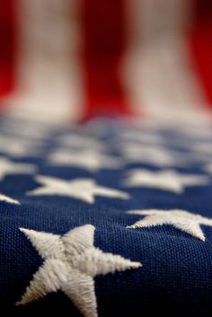 an american flag with white stars on it and the colors of the flag in the background