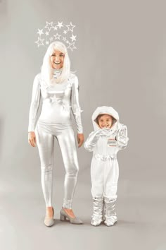 a woman and child dressed in white standing next to each other with stars on their head