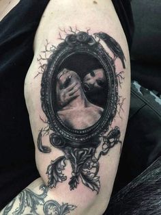 a woman's arm with a mirror on it that has an image of two women kissing