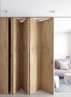 the room divider is made out of wood and has two doors open to reveal another room