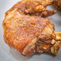 some meat is sitting on a table with other food items in the backgroud