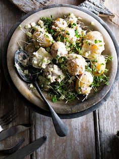 a bowl filled with meat and vegetables on top of a table next to utensils