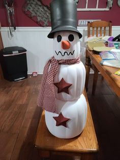 a snowman sitting on top of a wooden table