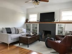 a living room filled with furniture and a flat screen tv mounted on the wall above a fireplace