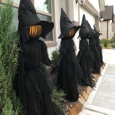 three black witches are standing in front of a house with their heads turned to look like they're coming out of the woods