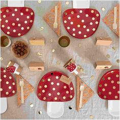 a table set with red and gold polka dot plates, napkins, silverware