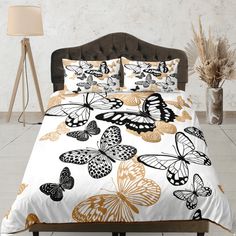 a bed with white and gold butterflies on it