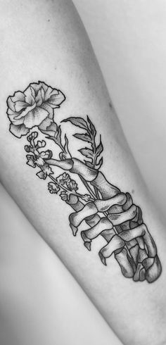 a black and white photo of a woman's leg with flowers on it