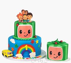 there is a birthday cake and two small toys on the top one has a tv