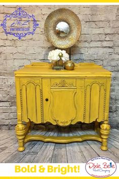 a yellow dresser sitting next to a brick wall