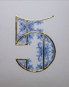 the letter f is made up of blue and gold designs on white paper with golden trim