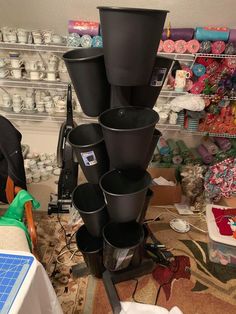 several black buckets stacked on top of each other in a room filled with craft supplies