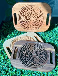 two wooden trays sitting on top of some green grass and plants in the background