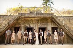 a group of people standing next to each other in front of a stone building with stairs