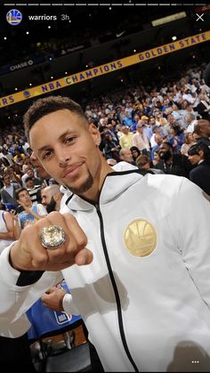 a man in a white jacket pointing at the camera with his hand out to someone else