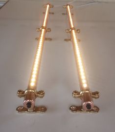 two lights that are sitting on top of a white tablecloth with gold trimmings