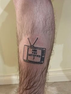 a man's leg with a tv tattoo on it that says are you satisfied?