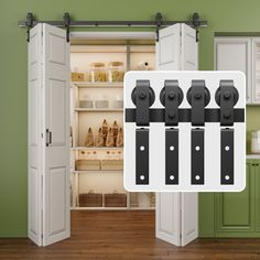 an open refrigerator door with black handles and knobs on the doors, in front of a green painted kitchen