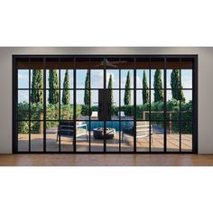 an open sliding glass door with the view of a pool and trees