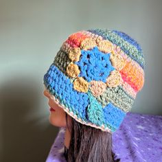 a crocheted hat on top of a mannequin's head in front of a wall