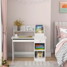 a bedroom with pink walls and a white desk in front of the bed is filled with children's books